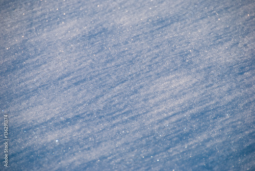Snow crystals closeup background with blue diagonal shadows