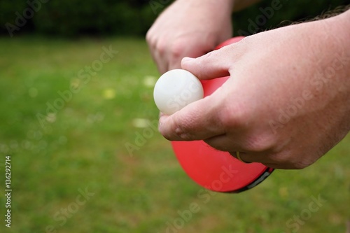 Outdoor table tennis. Man with red table tennis rackets and balls.