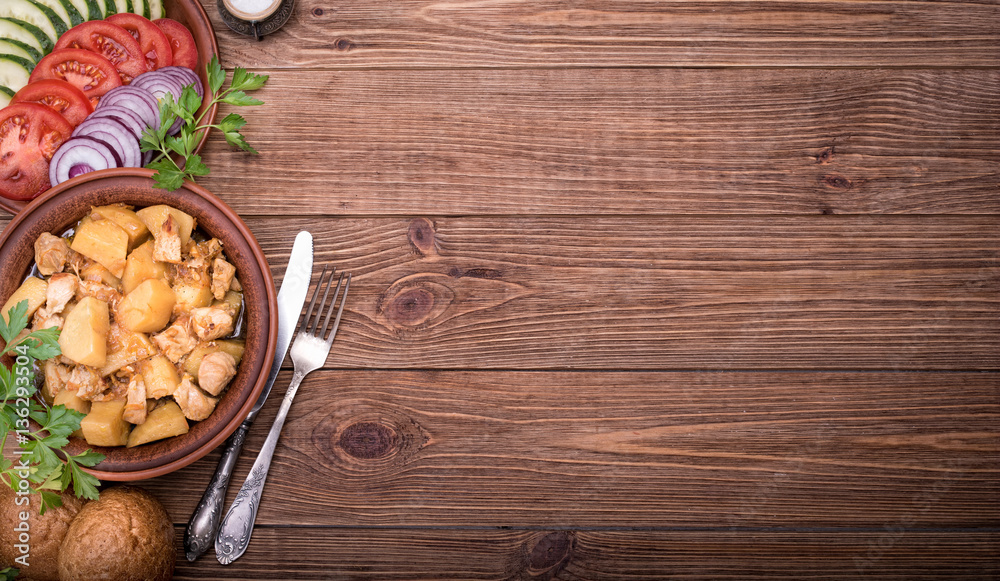 Meat stewed with potatoes in bowl on wooden background. Meat stewed with potatoes in bowl on wooden background.