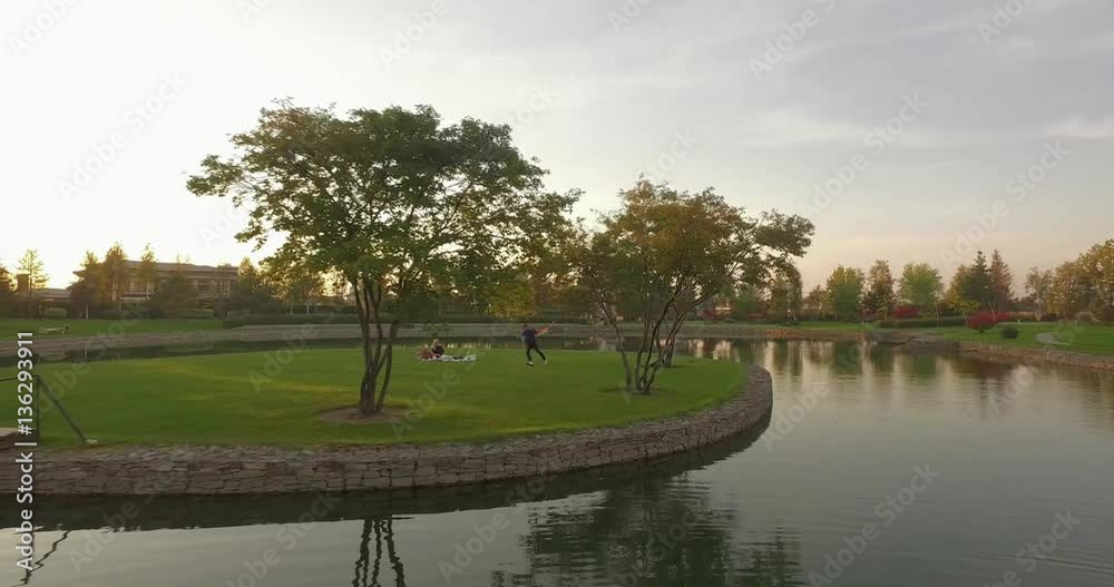 Idyllic countryside view with pond and houses on sunset. Rural aerial landscape. Reflections of the trees in a beautiful tranquil lake surface. Idyllic countryside view with pond and houses on sunset. Rural aerial landscape. Reflections of the trees in a beautiful tranquil lake surface.