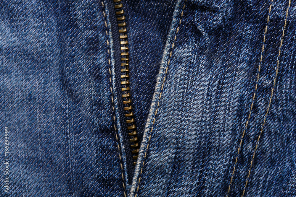 Denim jeans texture background with torn. The texture of the colored cotton fabric. Stitched texture jeans background. Fashion jeans button. Pocket and rivet on jeans. Fiber and fabric structure. Denim jeans texture background with torn. The texture of the colored cotton fabric. Stitched texture jeans background. Fashion jeans button. Pocket and rivet on jeans. Fiber and fabric structure.