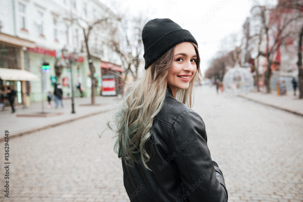 Attractive young lady wearing hat walking on the street