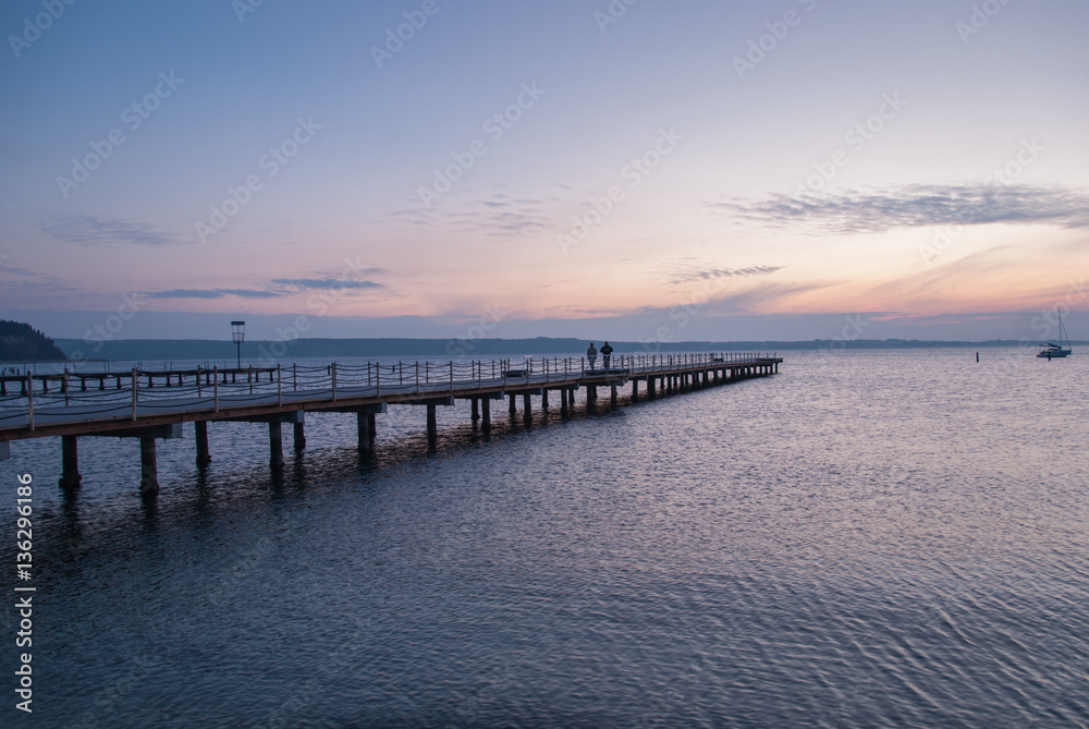 Wooden pier entering into the sea with colorful morning sky