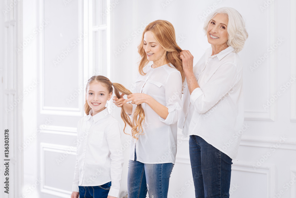 Positive family members making hairstyles for each other Positive family members making hairstyles for each other