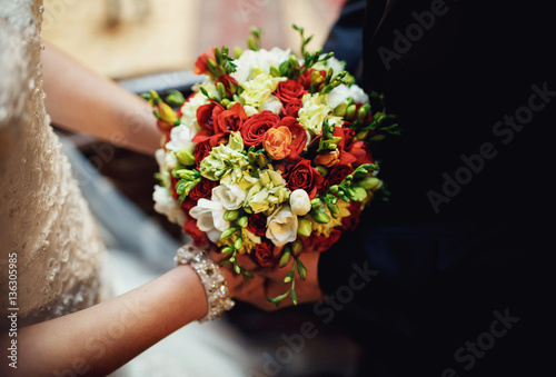 groom gives a wonderful bouquet of flowers to his wife