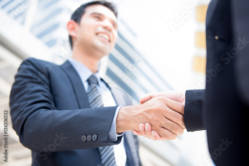 Businessman making handshake with a businesswoman