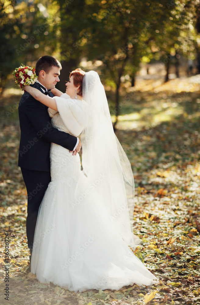 happy bride embraces her lover in the park