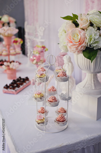 Candy bar. Dessert table for a party. Ombre cake, cupcakes, sweetness. 