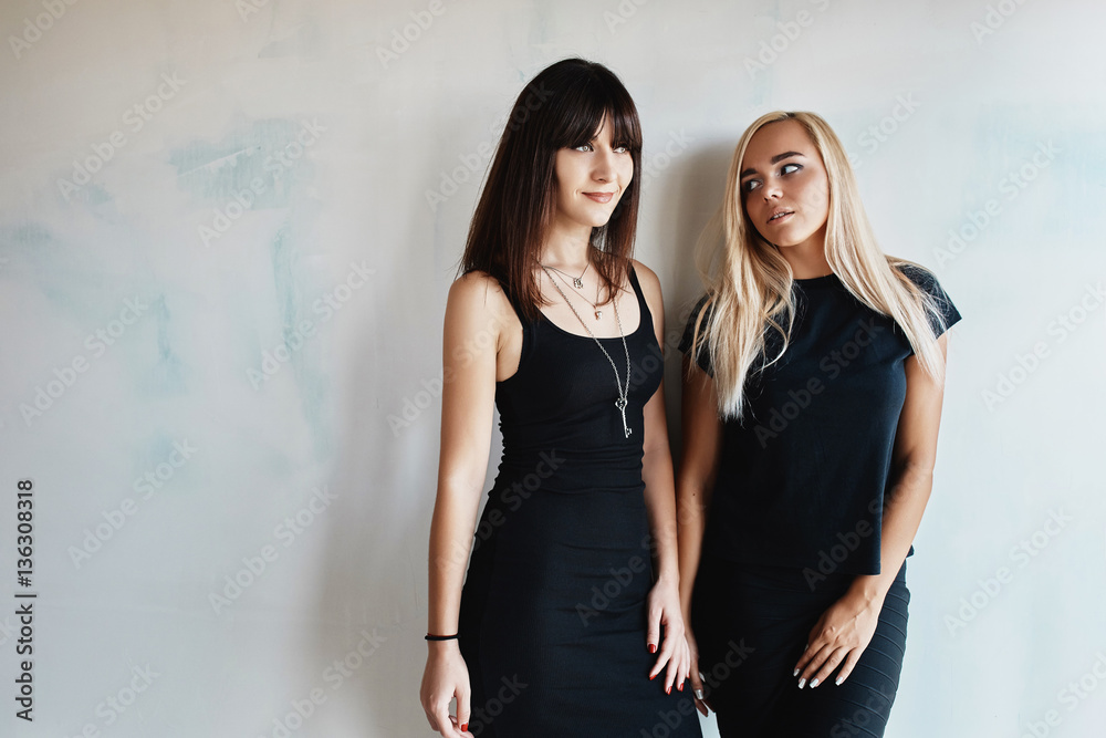 Two pretty woman in a black dress indoor