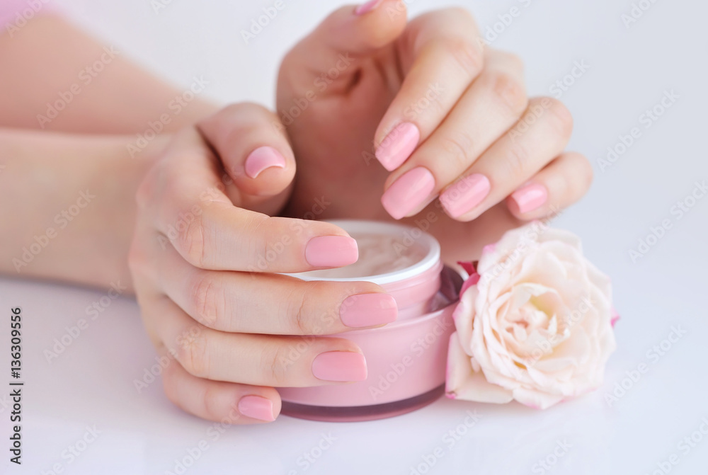 Hands of a woman with pink manicure with cream Hands of a woman with pink manicure with cream