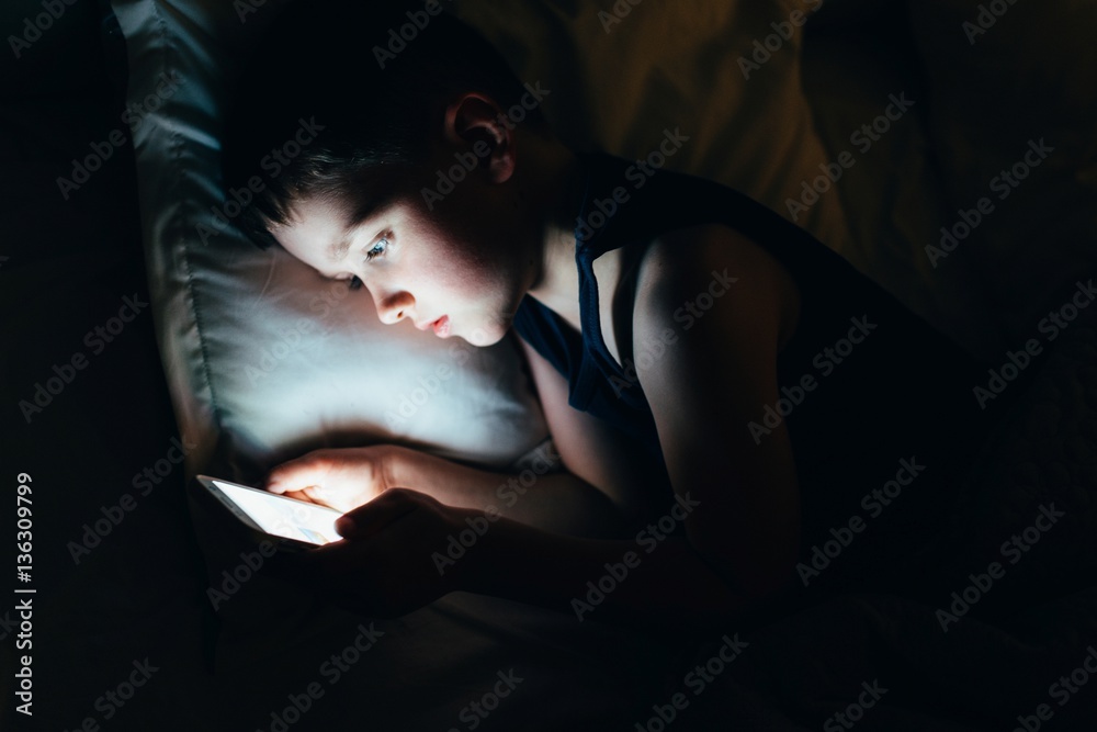 7 years old child boy using smartphone at night