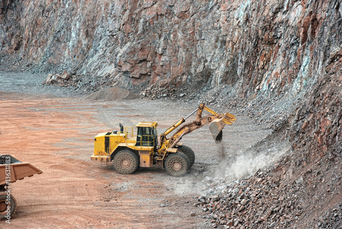earthmover in a open pit mine quarry. porphyry rock
