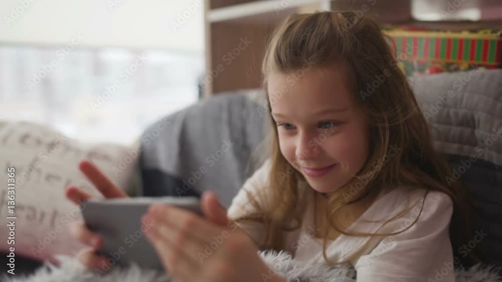 Little girl having fun with game in smartphone Little girl having fun with game in smartphone