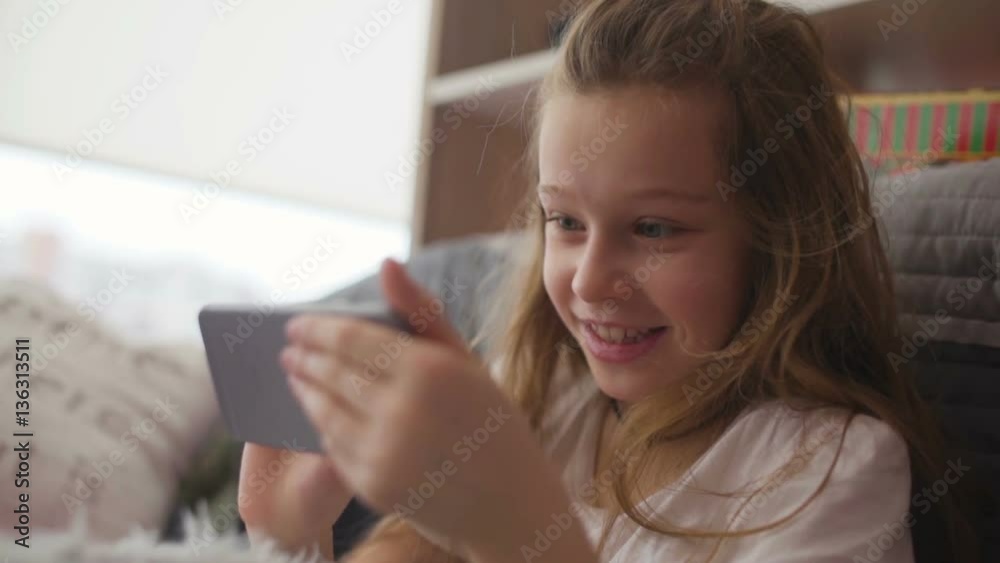 Little girl having fun with game in smartphone Little girl having fun with game in smartphone