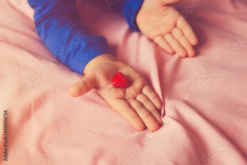 love and family concept. little girl holding heart in hands
