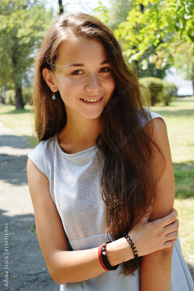 Portrait of beautiful teenage girl in blue blouse, against green Portrait of beautiful teenage girl in blue blouse, against green