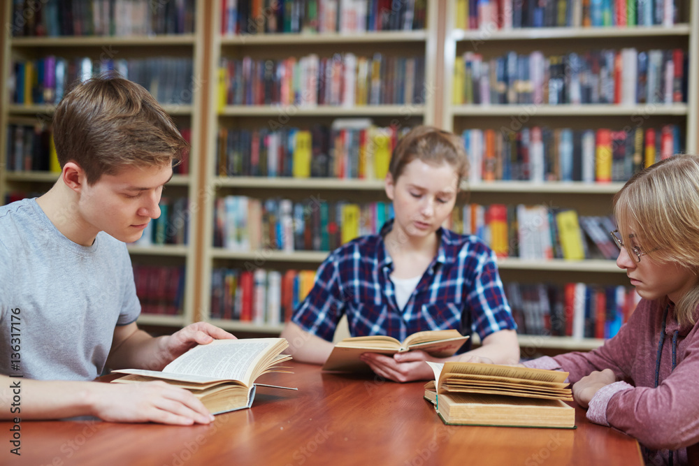 Adolescent people with books reading in library