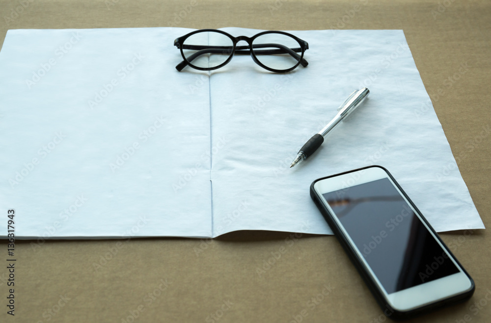Selected focus pen and glasses and cell phone with manual book Selected focus pen and glasses and cell phone with manual book
