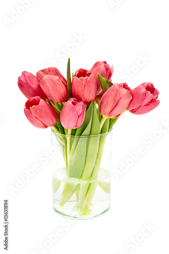 Red tulips bouquet in glass vase. Isolated over white background 
