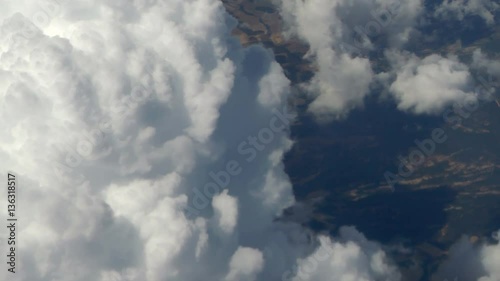 Close up large Clouds over the ground, seen from above and that slowly pass from right to left. Aerial shot. Top view.