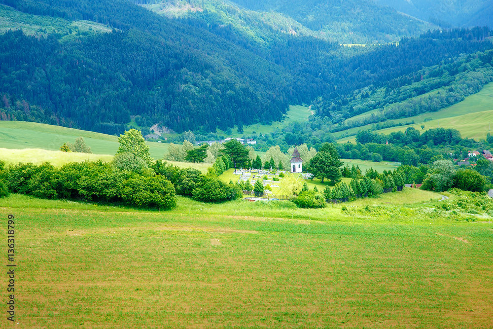 bell tower and cemetery and mountain landscape in slovakia.