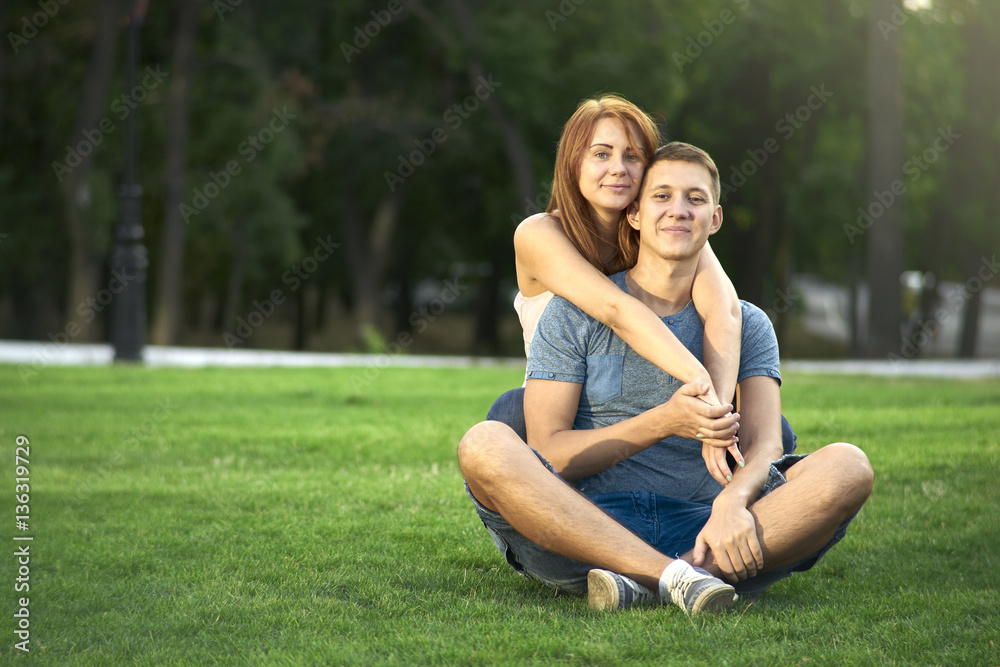 love couple sitting on the grass in the park love couple sitting on the grass in the park
