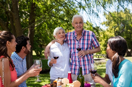 Happy family having red wine in park