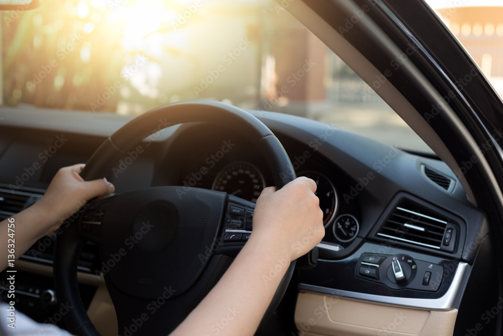 Woman hand holding steering wheel with sunlight Woman hand holding steering wheel with sunlight