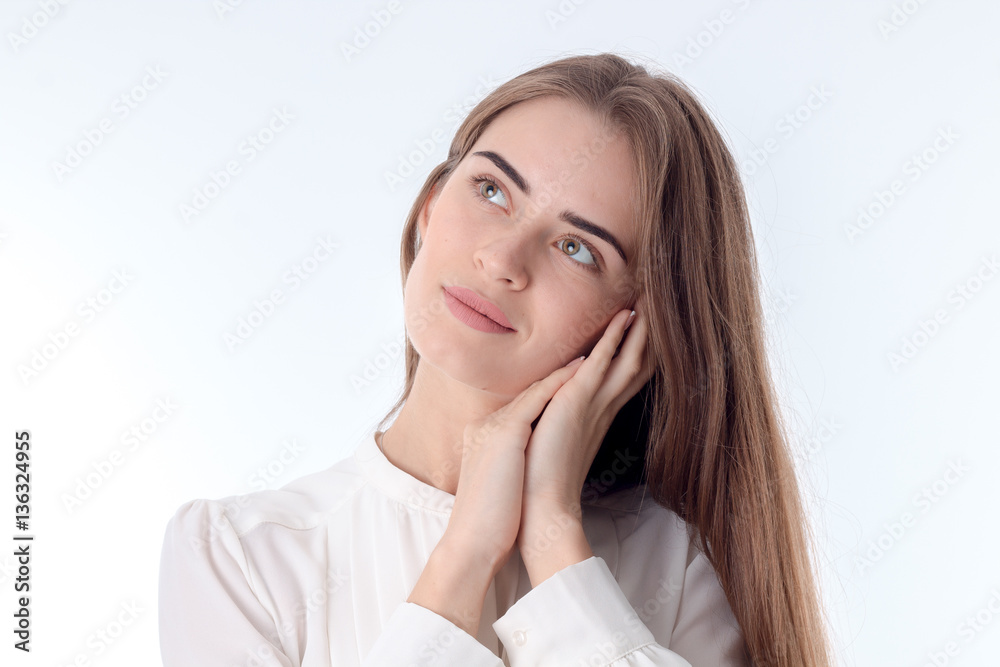Portrait of a young beautiful girl who folded her hands onto face looks away and smiling close-up Portrait of a young beautiful girl who folded her hands onto face looks away and smiling close-up