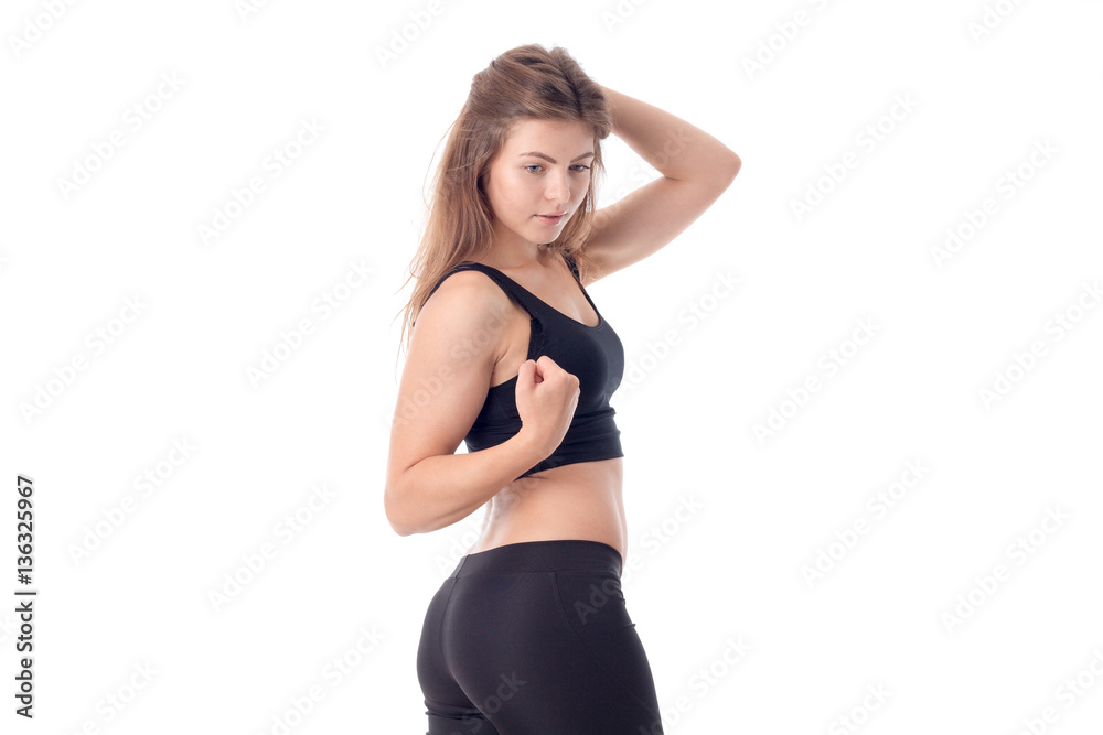 athletic girl in black stands sideways and clings to hair isolated on white background athletic girl in black stands sideways and clings to hair isolated on white background