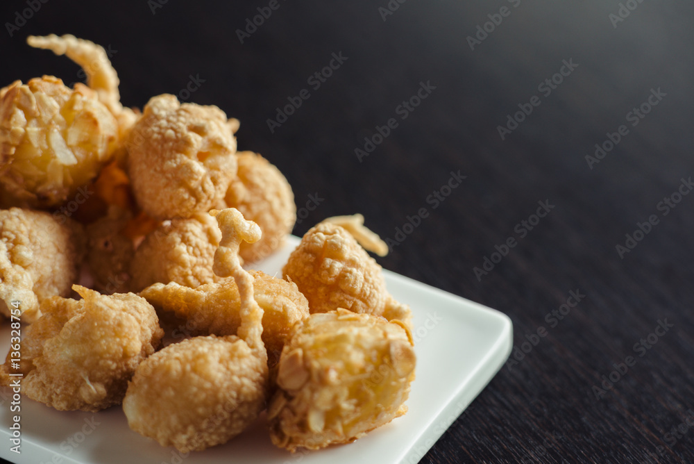 Cheese balls for beer on a white plate on a wooden table Cheese balls for beer on a white plate on a wooden table