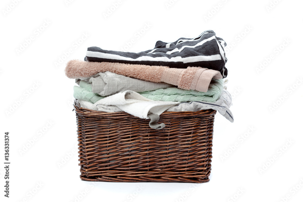 Obraz premium Clothes in a laundry wooden basket isolated on white background