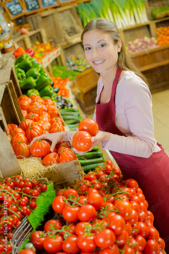 Shop worker carrying a crate of tomatoes Shop worker carrying a crate of tomatoes