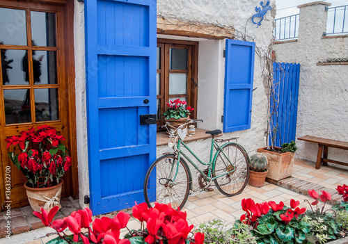 Vintage old bicycle in front of cute flowered house in Spain photo