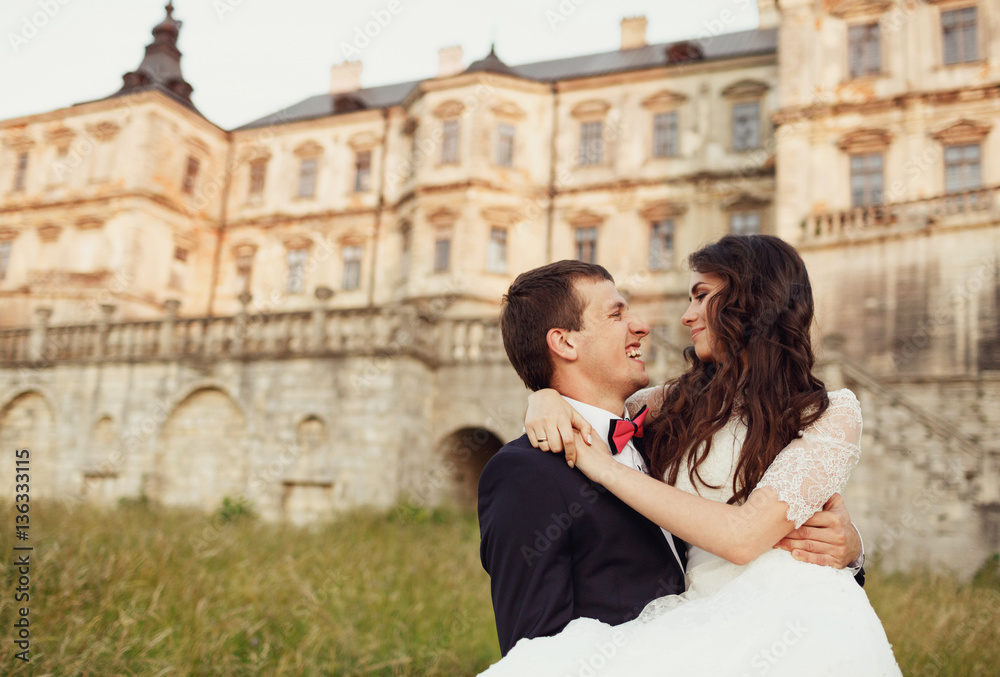 Fototapeta premium smiling groom holding hands in a happy bride