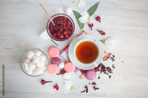 Serving table: tea with marshmallow, berry jam and macaroons.