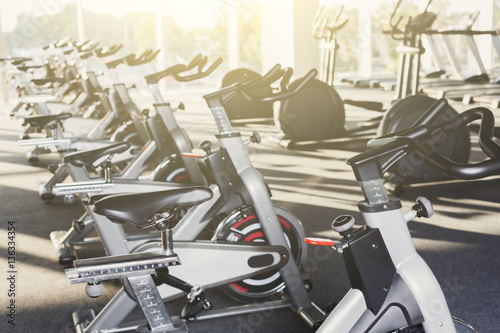 Modern gym interior with equipment, fitness exercise bikes