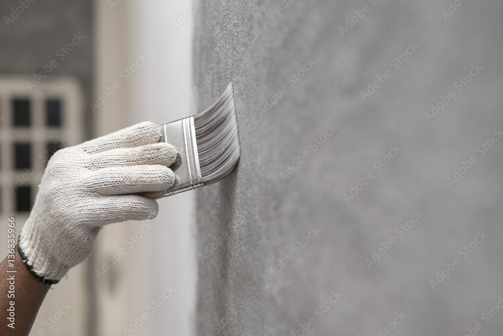 hand of worker use brush for color paint concrete Loft style on wall - obrazy, fototapety, plakaty 