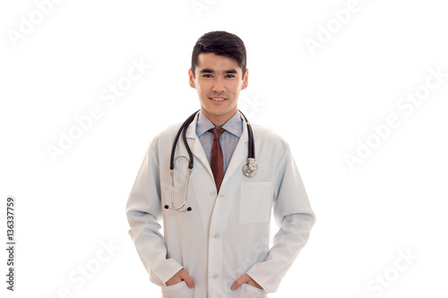 cheerful male doctor with stethoscope in uniform posing isolated on white background