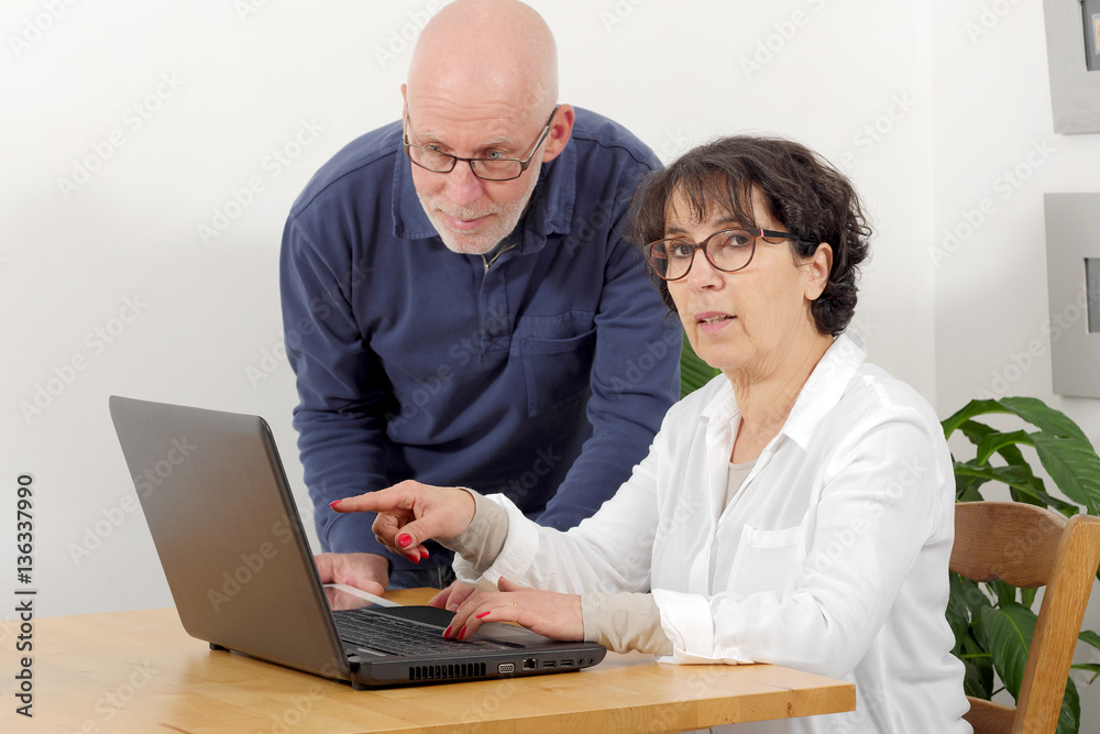 Portrait of a happy senior couple using laptop