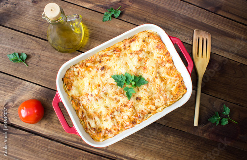 Homemade Meat lasagna with ingredients on wooden table
