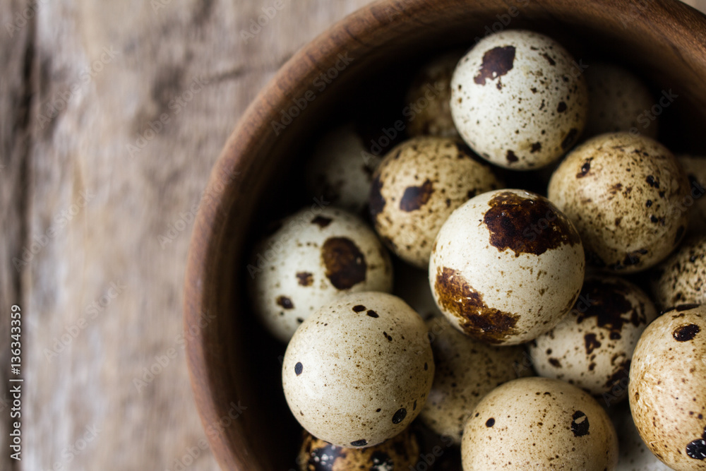 quail eggs on bowl on wood - top view quail eggs on bowl on wood - top view