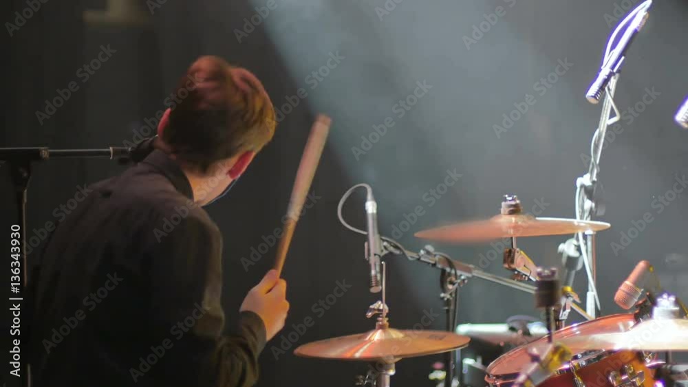 Young drummer playing on a concert on a drum set