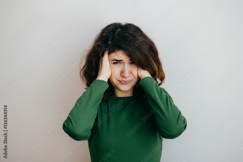 Young woman with headache, migraine, stress, insomnia, hangover on a light background Young woman with headache, migraine, stress, insomnia, hangover on a light background