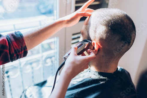 Woman barber cutting hair using razor - beauty, hair style concept