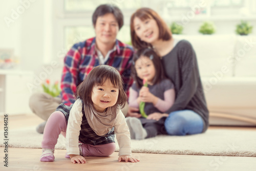 Young happy family with pretty daughters playing and having fun