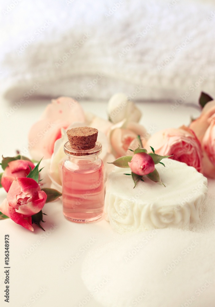 Rose aroma attar, white soap bar with foam, fresh pink garden flowers. Botanical skincare and aromatherapy. Vertical. Toned. Rose aroma attar, white soap bar with foam, fresh pink garden flowers. Botanical skincare and aromatherapy. Vertical. Toned.