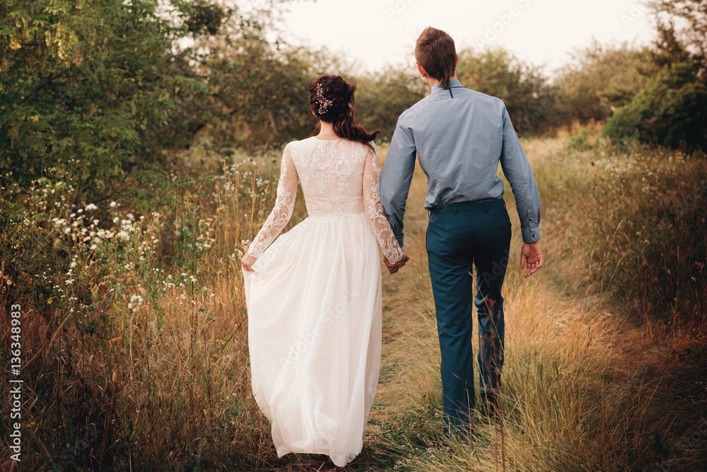Couple having a date, holding hands and kissing or hugging.Unrecognizable people, closeup of legs. Couple having a date, holding hands and kissing or hugging.Unrecognizable people, closeup of legs.