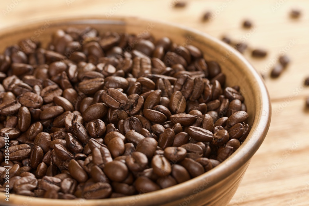 coffee beans in bowl on a wooden background coffee beans in bowl on a wooden background