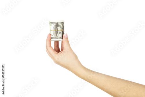 Female hand with twisted stack of dollars on white background.